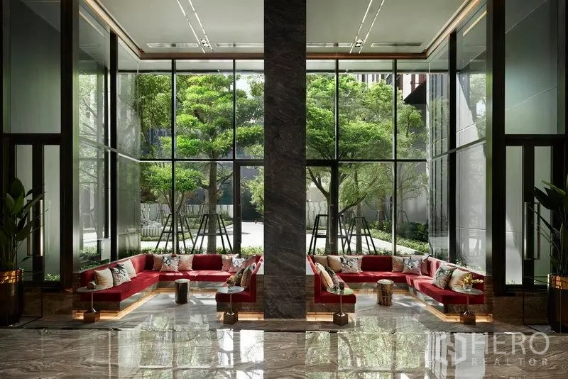 คอนโด ขายในRatchathewi, Bangkok - ล็อบบี้เพดานสูง โซฟาสีแดง กระจกเต็มบานมองเห็นต้นไม้เขียว
