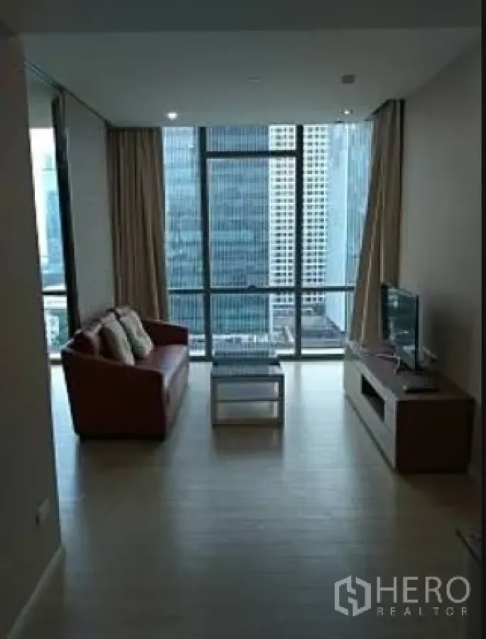 公寓 出租在Watthana, Bangkok - 开放式起居区，沙发与电视柜对望整面落地窗城市景观。