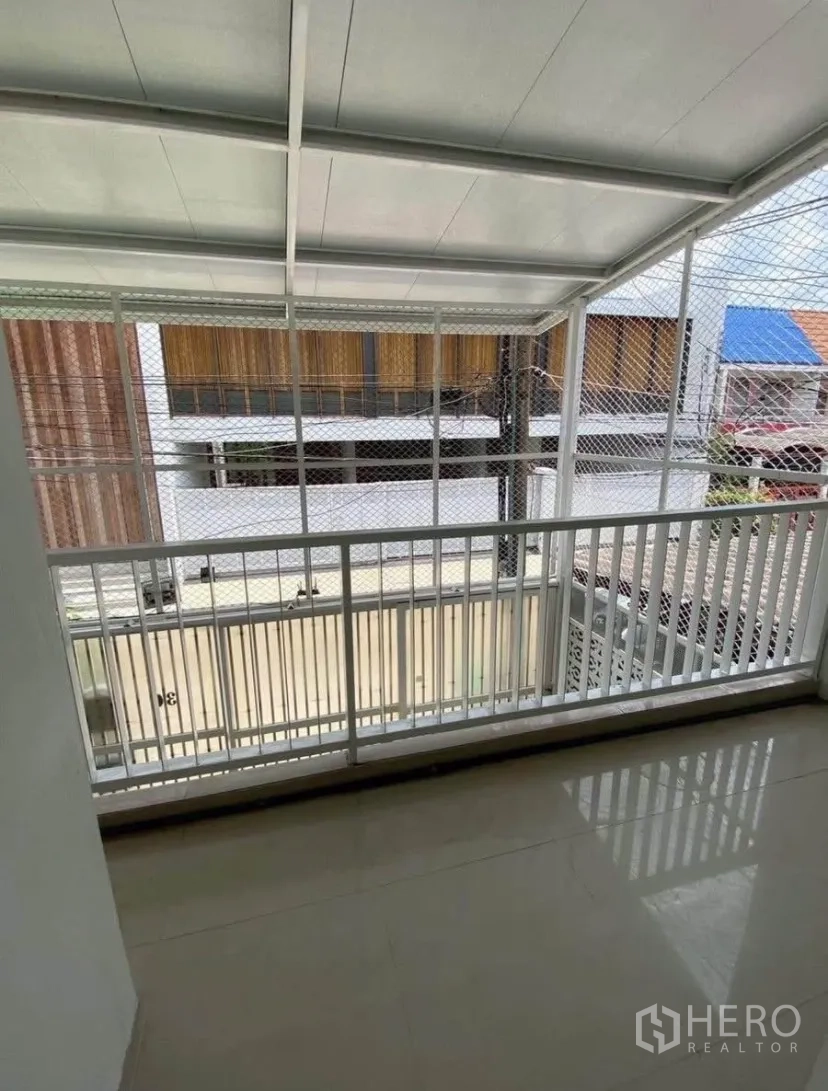 联排别墅 for rent in Phra Khanong, Bangkok - 有顶阳台，白色栏杆与安全网，可眺望前方巷道。