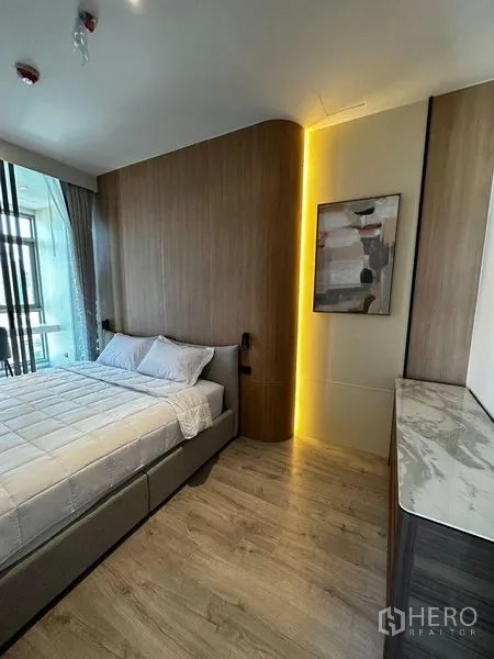 คอนโด ให้เช่าในWatthana, Bangkok - ห้องนอนบรรยากาศอบอุ่น ผนังลายไม้ ไฟซ่อน เตียงควีน และท็อปหินอ่อนข้างหน้าต่าง