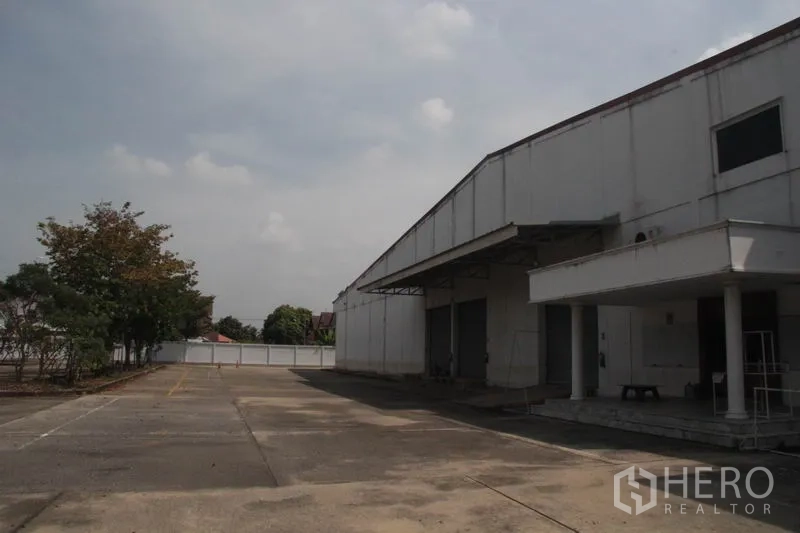 货栈 出租在Lam Luk Ka, Pathum Thani - 仓库外观，带雨棚装卸区与宽阔硬化场地，位于Lam Luk Ka。