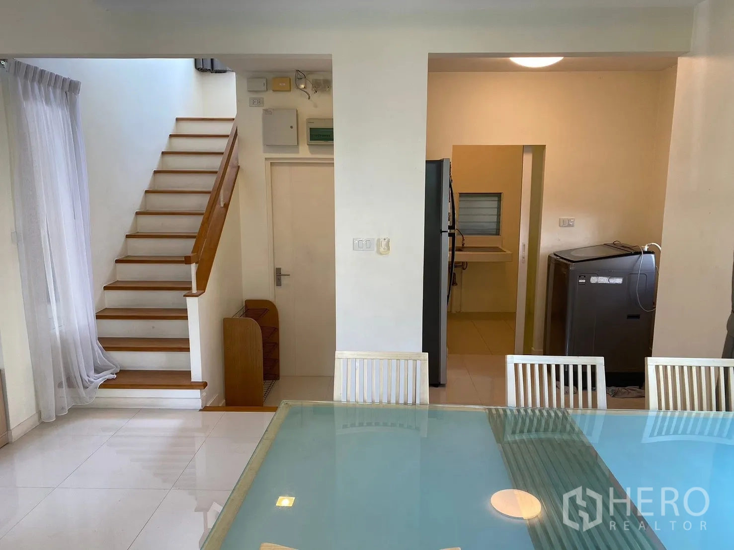 Detached House for rent in Prawet, Bangkok - Dining area beside kitchen and stairs with refrigerator and washing machine.