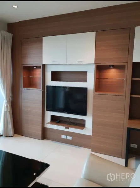 公寓 出租 - 客厅多功能电视墙，内置柜体、展示格与平板电视。