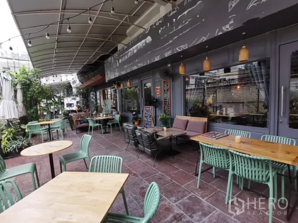 零售空间 出租在Watthana, Bangkok - 宽敞的庭院区，临大玻璃窗摆放多张餐桌。