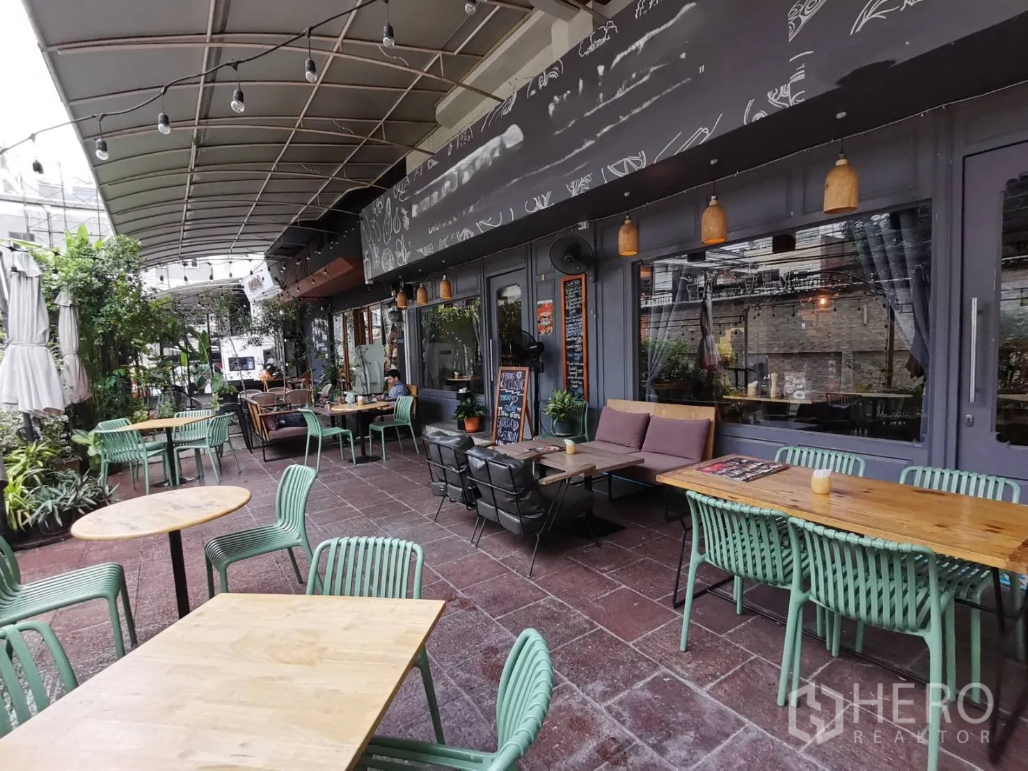 零售空间 出租在Watthana, Bangkok - 宽敞的庭院区，临大玻璃窗摆放多张餐桌。