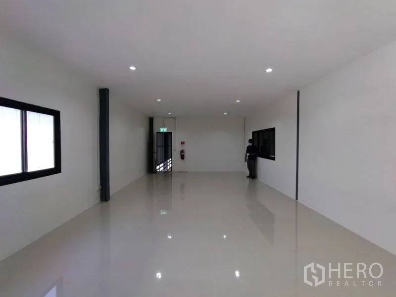 Warehouse for rent in Bang Phli, Samut Prakan - Office room with windows, downlights and an emergency exit door inside the warehouse.