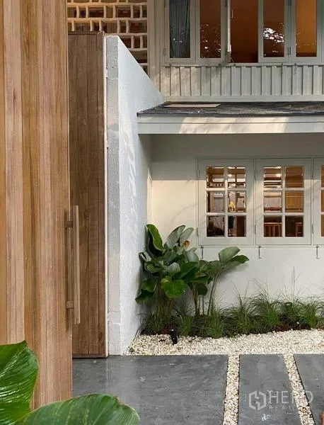บ้าน ให้เช่าในWatthana, Bangkok - ประตูไม้ทางเข้าและหน้าต่างสีขาวรายล้อมด้วยต้นไม้