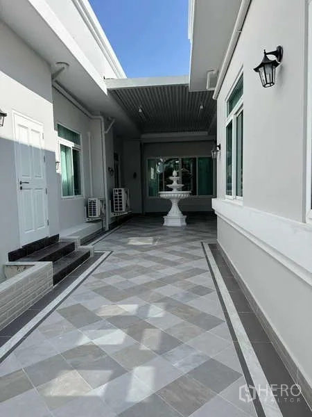 Detached House for rent in Samut Prakan - Covered courtyard with patterned tiles, wall lights, and a decorative fountain.
