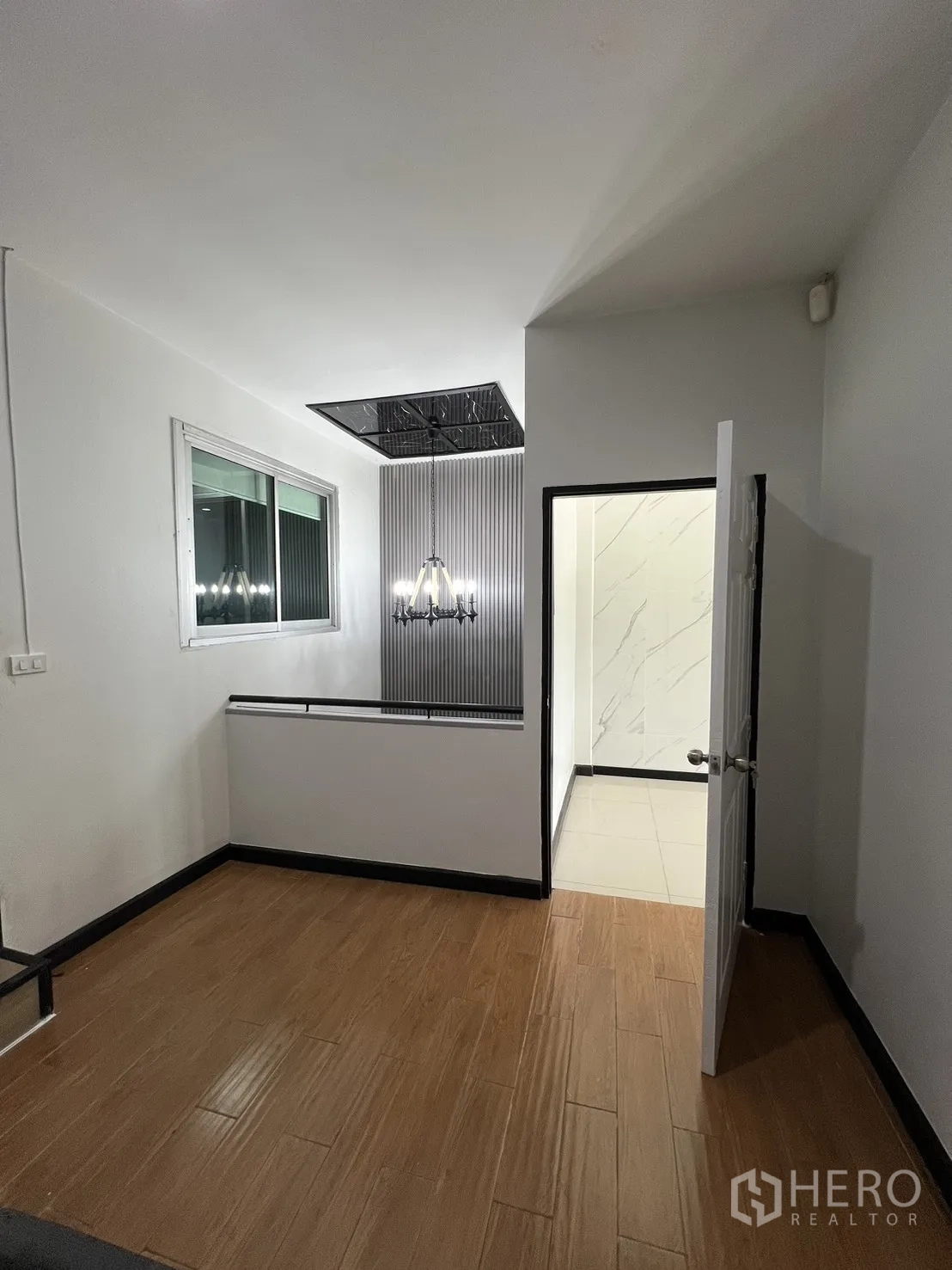 ทาวน์เฮาส์ for rent in Watthana, Bangkok - โถงชั้นบน พื้นไม้ มีหน้าต่างและโคมระย้าใกล้บันได