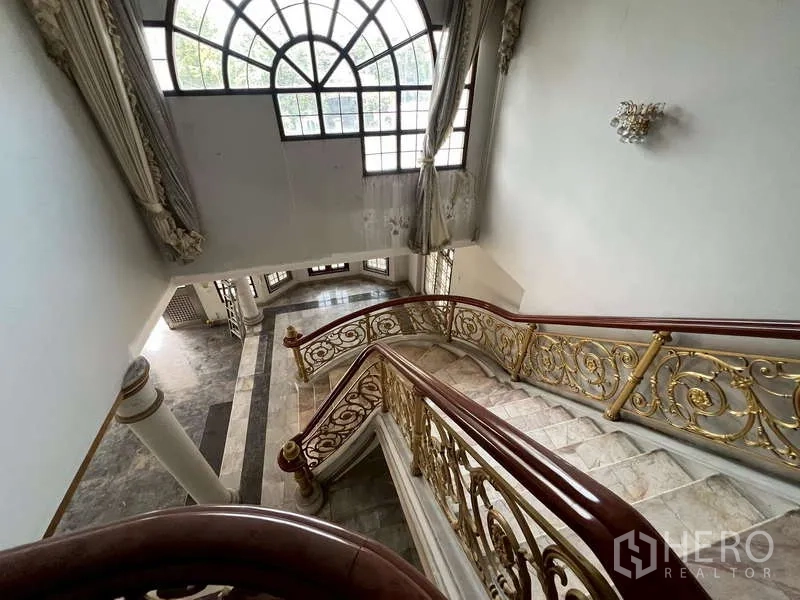 Detached House for rent in Prawet, Bangkok - View from the upper landing to the foyer with arched window and staircase.