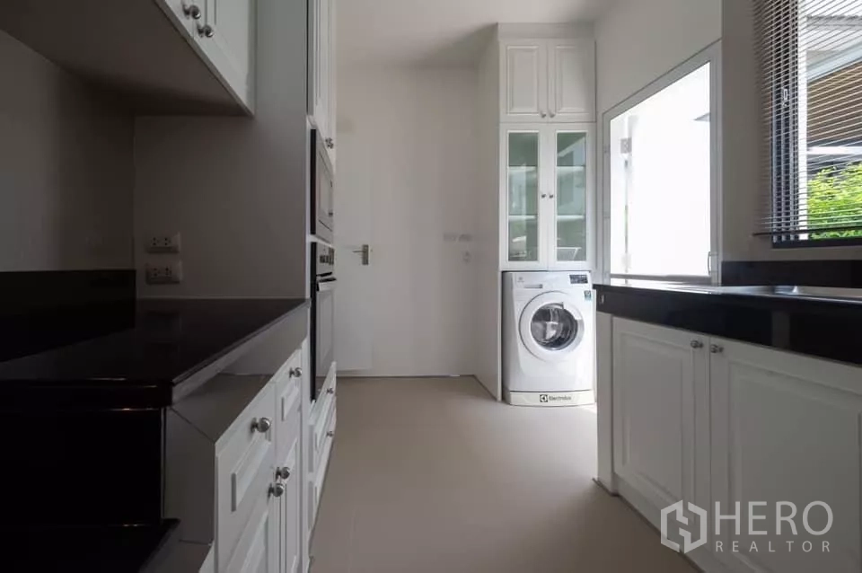 บ้าน ให้เช่าในPrawet, Bangkok - ห้องซักล้างและครัวไทย ตู้สีขาว ท็อปสีดำ พร้อมเครื่องซักผ้า