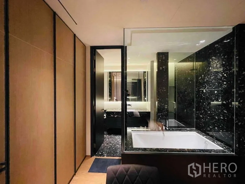 คอนโด ให้เช่าในKhlong Toei, Bangkok - ห้องน้ำหินอ่อนสีดำพร้อมอ่างอาบน้ำบิวท์อินหลังผนังกระจกและไฟบรรยากาศ