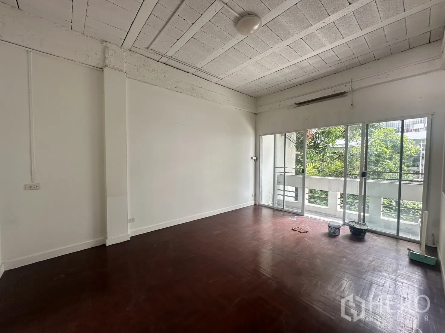 Home Office for rent in Watthana, Bangkok - Upper-floor room with sliding glass doors to a balcony and tree views.