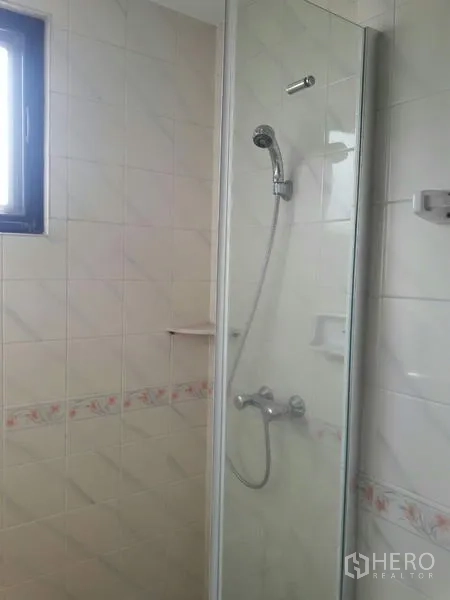 Condominium for rent in Pathum Wan, Bangkok - Bathroom close‑up of glass shower enclosure with handheld showerhead and tiled walls.