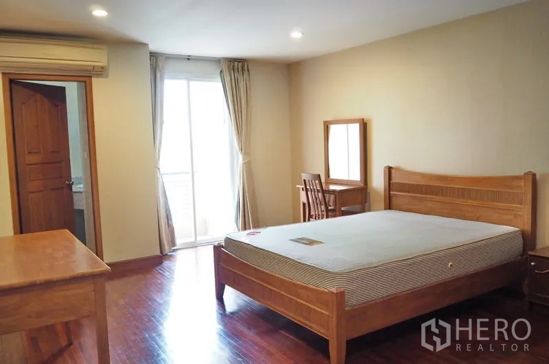 Condominium for rent in Pathum Wan, Bangkok - Bedroom with sliding door opening to the balcony and natural light