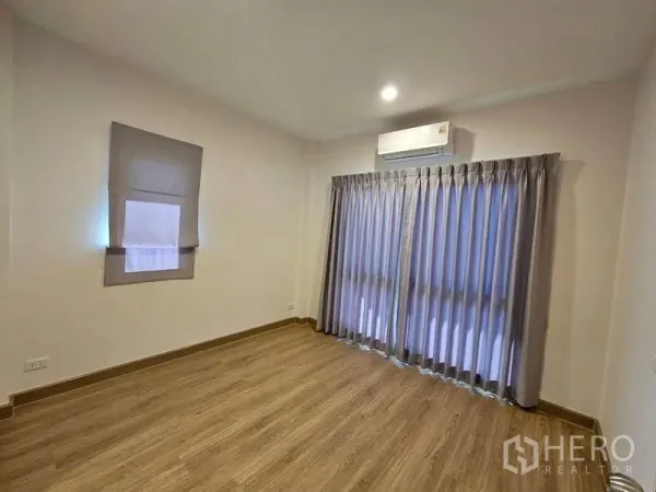 Detached House for rent in Bang Phli, Samut Prakan - Air-conditioned bedroom with full-height curtains and sliding glass doors.