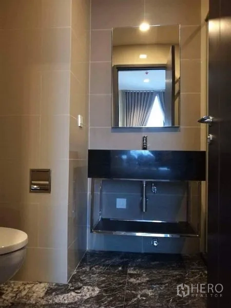 คอนโด ให้เช่าในWatthana, Bangkok - ห้องน้ำสไตล์โมเดิร์นพร้อมอ่างล้างหน้าหินสีดำ กระจก และพื้นลายหินอ่อน
