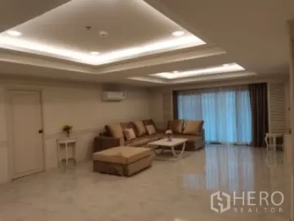 อพาร์ทเมนท์ ให้เช่าในWatthana, Bangkok - ห้องนั่งเล่นกว้างพร้อมไฟฝ้าหลุม โซฟาสีเบจ พื้นเงา และประตูบานเลื่อนติดผ้าม่าน