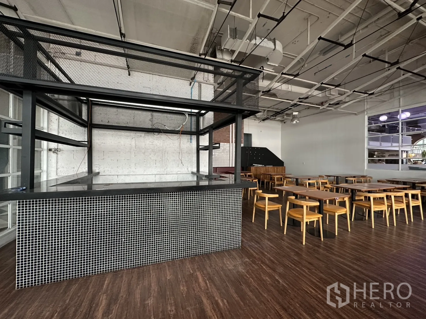零售空间 for rent in Watthana, Bangkok - 中央服务吧台，黑色金属框架与马赛克瓷砖台座，裸露天花。