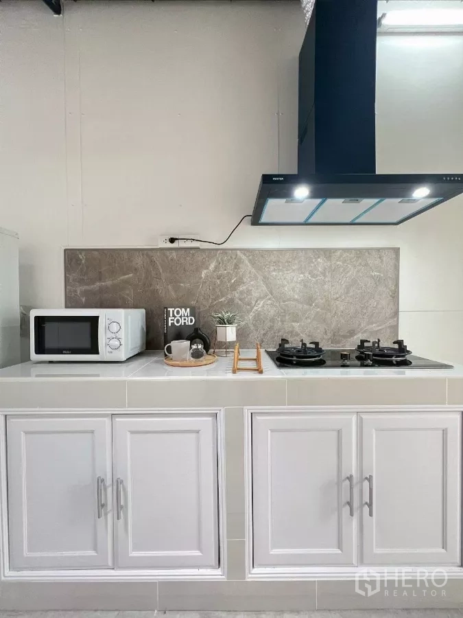 บ้าน ให้เช่าในHuai Khwang, Bangkok - มุมมองเต็มของครัว พร้อมเตาแก๊สคู่ ไมโครเวฟ และผนังกระเบื้อง