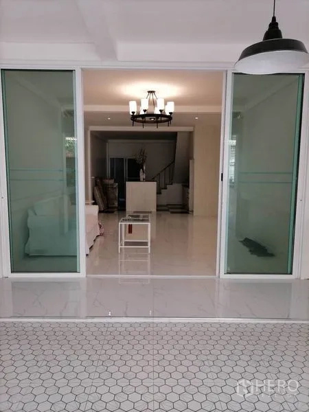 ทาวน์เฮาส์ ให้เช่าหรือขายในKhlong Toei, Bangkok - ประตูกระจกบานเลื่อนเปิดสู่ห้องนั่งเล่นสว่างพร้อมโคมระย้า