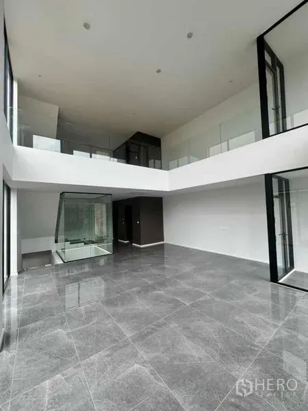 สำนักงานที่บ้าน ให้เช่าหรือขายในLat Phrao, Bangkok - พื้นที่นั่งเล่น/ทำงานเพดานสูงสองชั้น กระจกเต็มผนังและชั้นลอย.