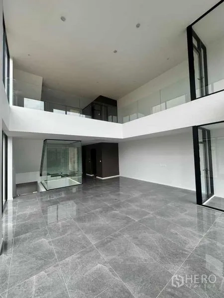 สำนักงานที่บ้าน ให้เช่าหรือขายในLat Phrao, Bangkok - พื้นที่นั่งเล่น/ทำงานเพดานสูงสองชั้น กระจกเต็มผนังและชั้นลอย.