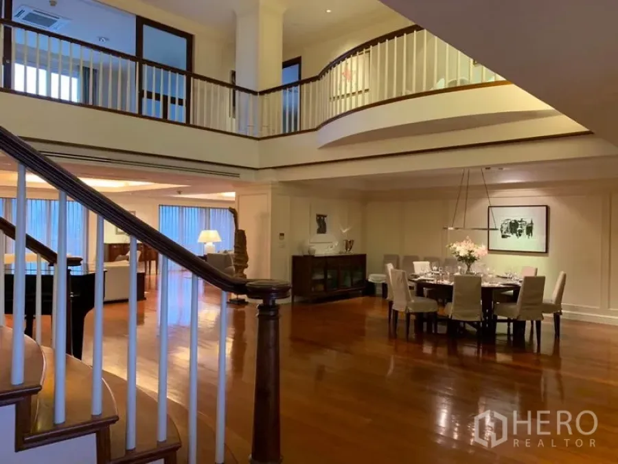 คอนโด ให้เช่าหรือขายในWatthana, Bangkok - ห้องนั่งเล่นและรับประทานอาหารเพดานสูงสองชั้น พร้อมบันไดโค้งและชั้นลอย ในคอนโดหรูย่านวัฒนา กรุงเทพฯ