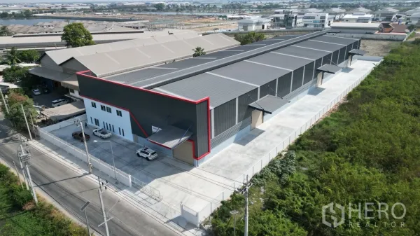 คลังสินค้า ให้เช่าในMueang Samut Prakan, Samut Prakan - ภาพมุมสูงของโกดังสร้างใหม่สีเทาพร้อมเส้นขอบสีแดง ลานคอนกรีตกว้างและออฟฟิศติดอาคาร ที่สมุทรปราการ