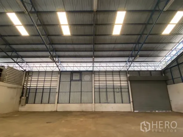 工厂 出租在Lat Lum Kaeo, Pathum Thani - 仓库内墙，排灯和大卷闸门。