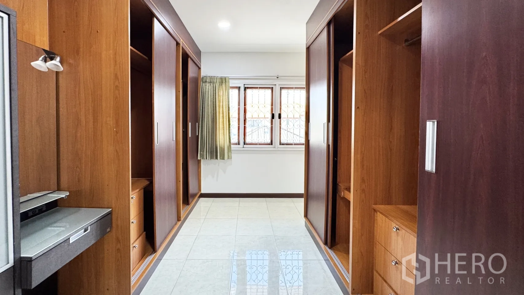 独栋房屋 for rent in Suan Luang, Bangkok - 步入式衣帽间走廊，两侧为内置木质衣柜并设有窗户。