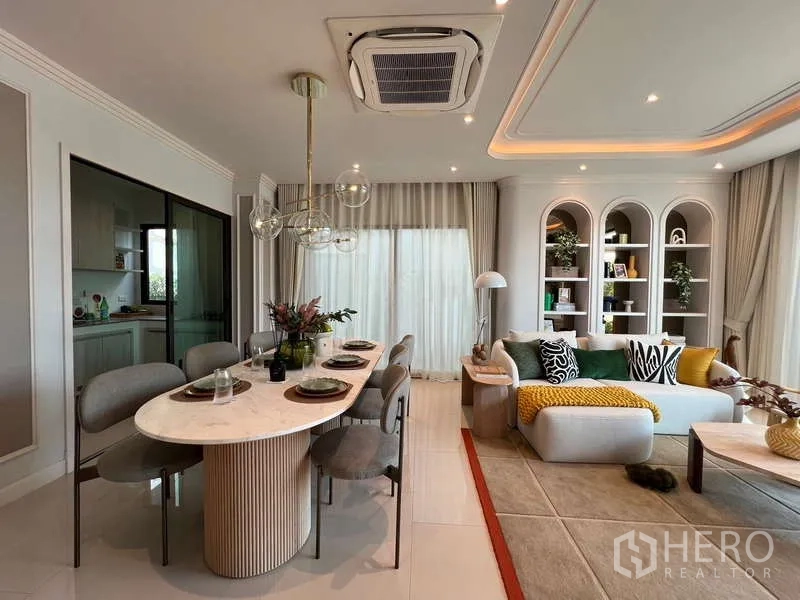 Detached House for sale in Saphan Sung, Bangkok - Dining zone with marble table, globe pendant lights and sliding door to the kitchen beside the lounge.