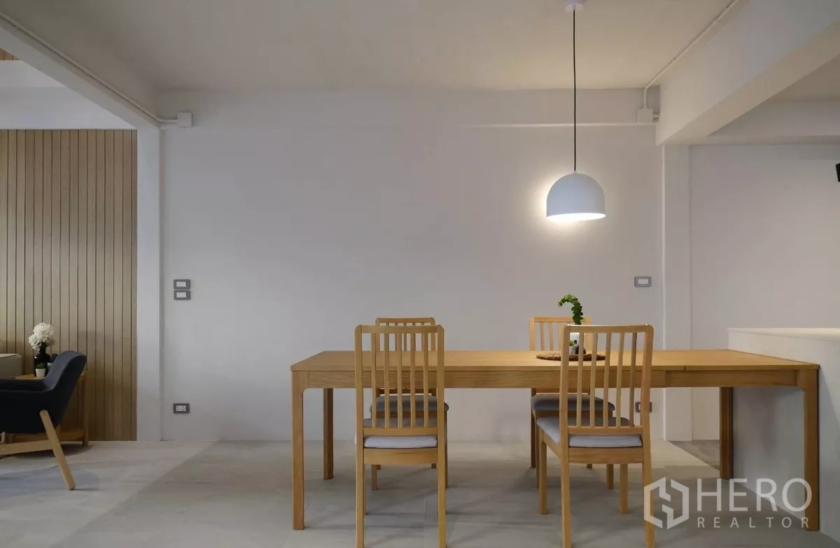 联排别墅 出租或出售在Watthana, Bangkok - 极简餐区，木桌四椅与半球吊灯。