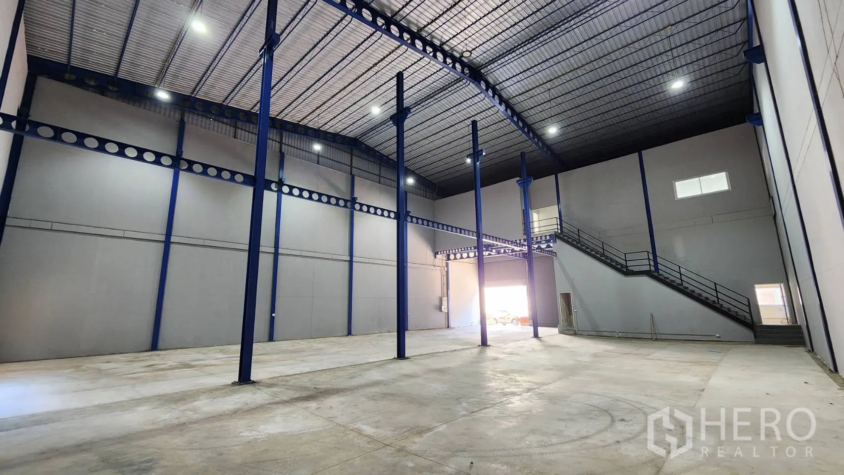 คลังสินค้า ให้เช่าในKrathum Baen, Samut Sakhon - พื้นที่โกดังโล่ง เพดานกันความร้อน ไฟสว่าง ประตูม้วนสองบาน และบันไดสู่ชั้นลอยออฟฟิศ