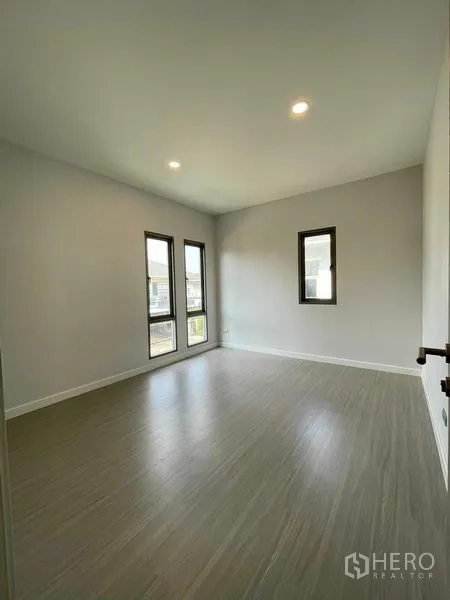 บ้าน ขายในNuea Khlong, Krabi - ห้องนอนรับแสงดี พร้อมหน้าต่างสูงทรงแคบและพื้นลายไม้โทนอ่อน