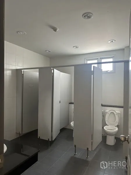 工厂 出租在Bang Sao Thong, Samut Prakan - 公共卫生间配多间隔断厕位与灰色地砖。