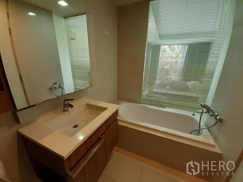 公寓 出售在Watthana, Bangkok - 现代浴室，洗手台与靠窗浴缸，配百叶帘。