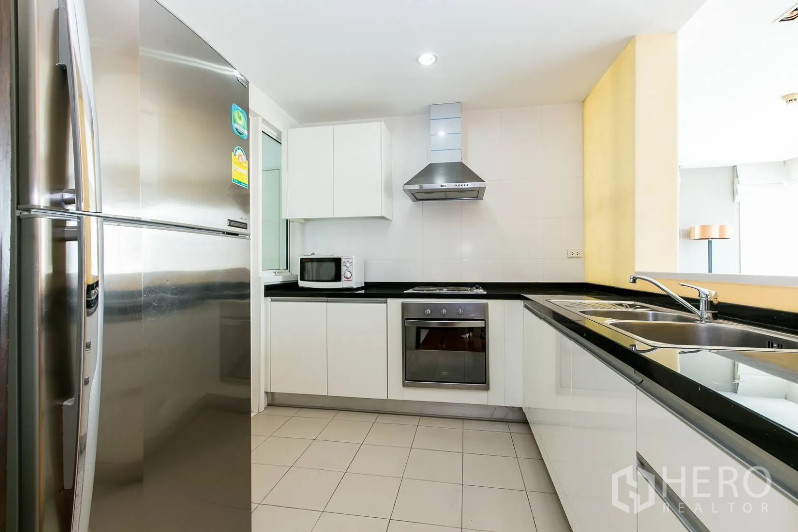 คอนโด ให้เช่าหรือขายในKhlong Toei, Bangkok - ครัวรูปตัว U ตู้สีขาว ท็อปหินสีดำ พร้อมเครื่องใช้สแตนเลสครบ