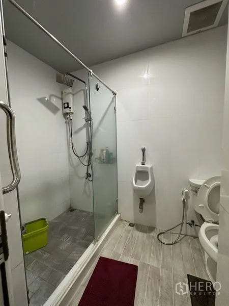 Warehouse for sale in Bang Khen, Bangkok - Bathroom with glass-enclosed shower, urinal and toilet inside the facility.