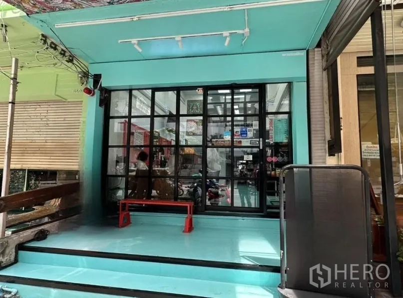 店屋 for sale in Watthana, Bangkok - 素坤逸路面店铺外立面，青绿色墙面与黑框落地玻璃入口台阶。