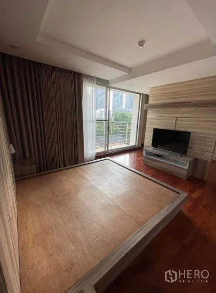 คอนโด ให้เช่าในKhlong Toei, Bangkok - ห้องนอนเตียงแพลตฟอร์ม พร้อมชั้นวางทีวี และระเบียงชมวิวเมือง ผ้าม่านสูงจรดเพดาน