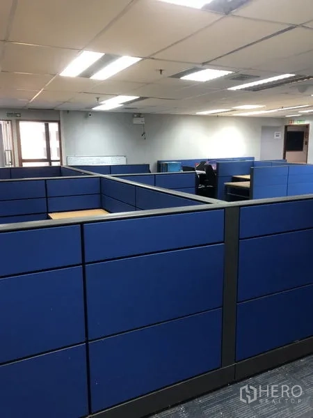 สำนักงาน ให้เช่า - พื้นที่ทำงานแบบโอเพ่นสเปซพร้อมคูบิคสีน้ำเงินและไฟฟลูออเรสเซนต์บนเพดาน