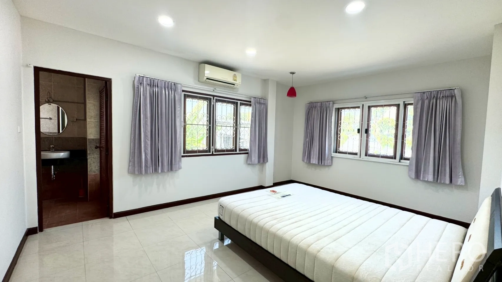 独栋房屋 for rent in Suan Luang, Bangkok - 卧室配床架、空调与套内卫浴入口，地面为瓷砖。