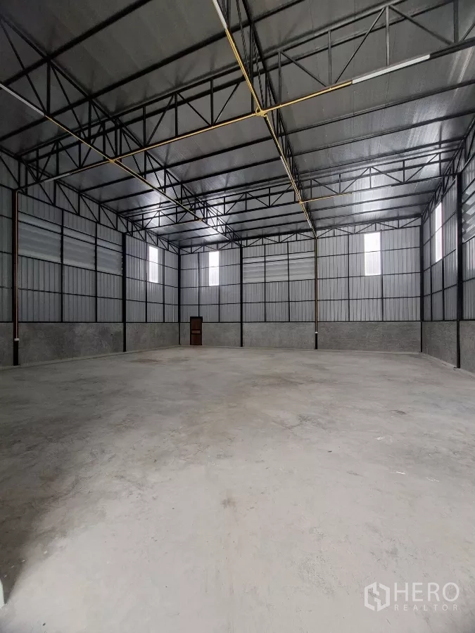 Warehouse for rent in Lam Luk Ka, Pathum Thani - Spacious warehouse interior featuring high ceiling, ventilation windows and clear open span for racking.