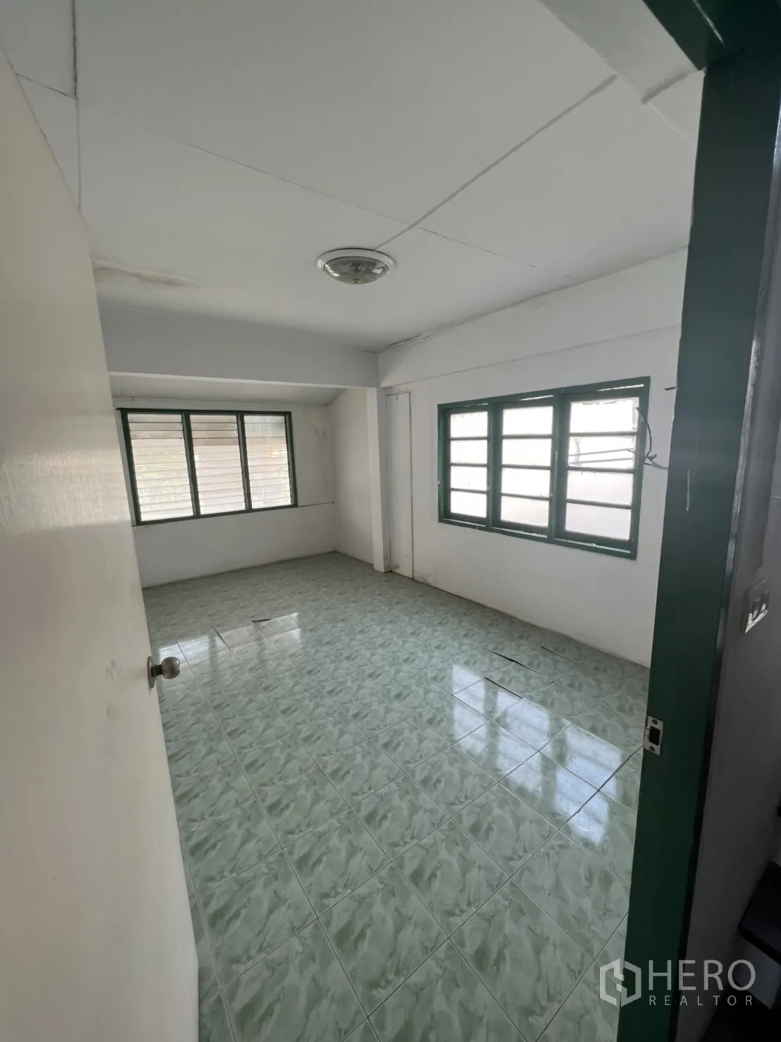 Townhouse for sale in Watthana, Bangkok - Upper floor room with green ceramic tiles and multiple windows for natural light.