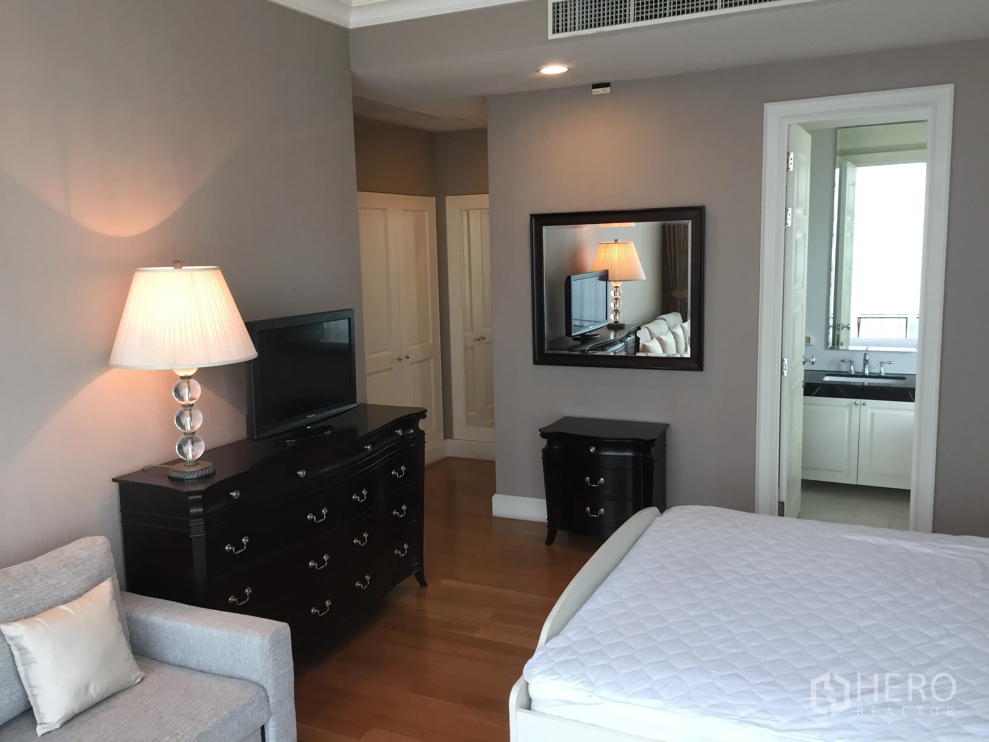 คอนโด ให้เช่าในWatthana, Bangkok - ห้องนอนใหญ่พื้นไม้ มีตู้ลิ้นชักสีเข้ม และประตูเข้าห้องน้ำในตัว