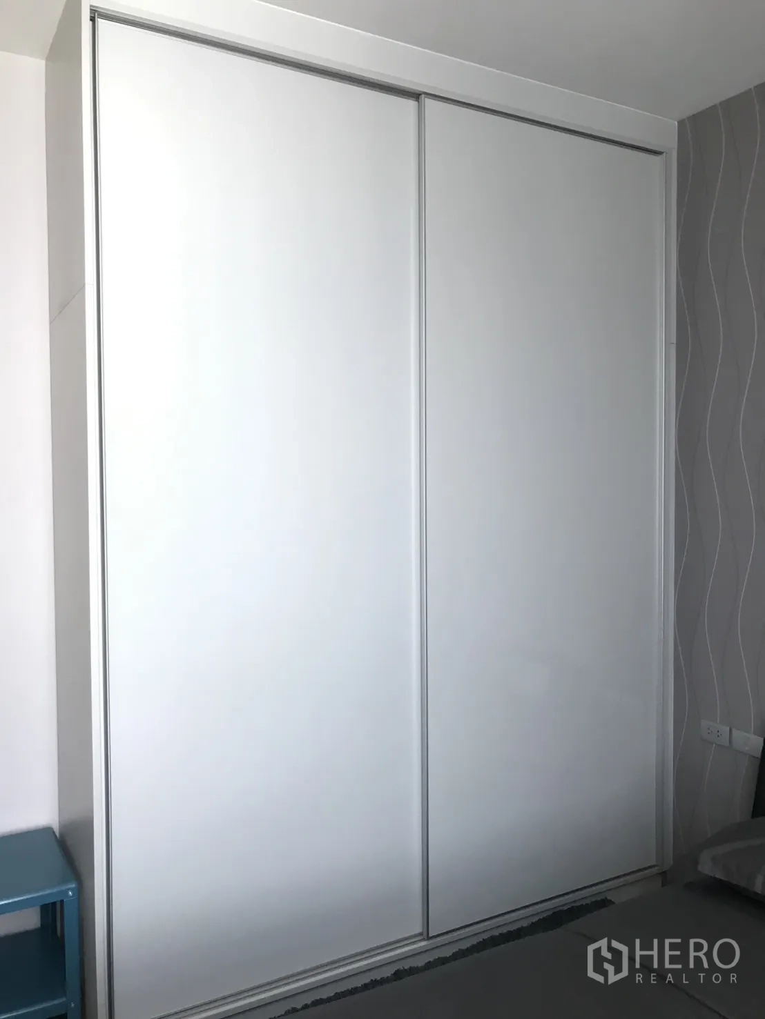 Condominium for rent in Watthana, Bangkok - Bedroom featuring large white sliding wardrobe doors for built-in storage.