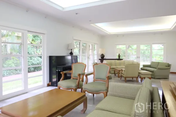 独立式住宅 出租在Bang Phli, Samut Prakan - 客厅另一角度，层次天花与面向花园的窗户，采光充足。