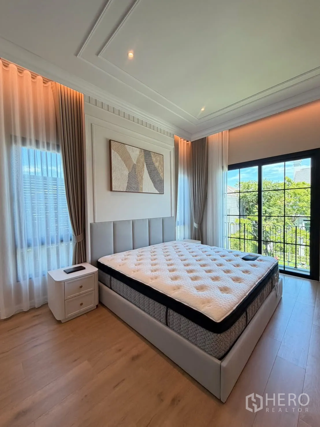 Detached House for rent in Saphan Sung, Bangkok - Bedroom with balcony doors opening to green views and soft cove lighting.