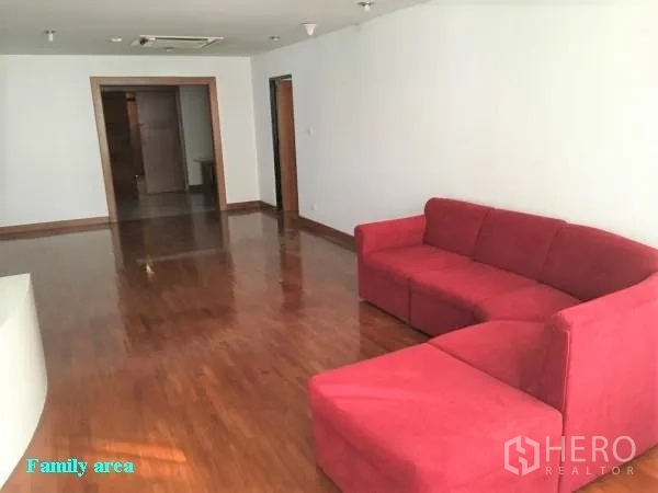 公寓 出租在Khlong Toei, Bangkok - 大型家庭起居区，红色L形沙发，抛光木地板。